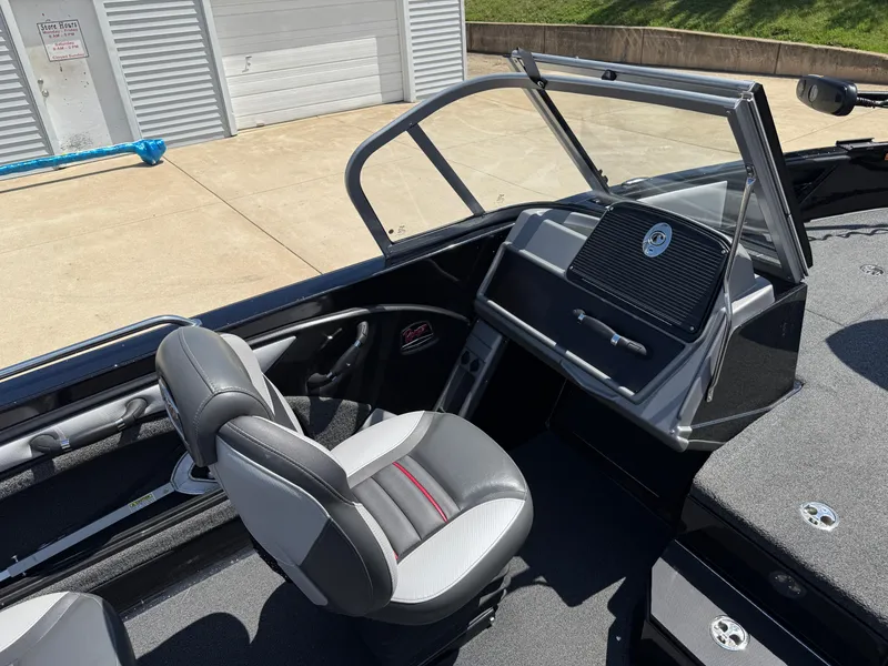 Slide: The Image of 2022 Ranger 1880MS boat interior with gray seating and dashboard, parked outdoors. - 26