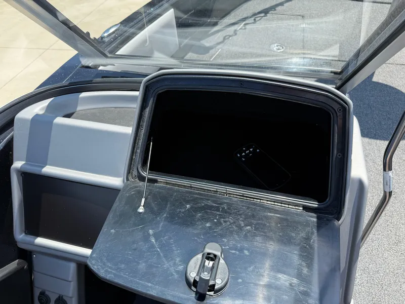 Slide: The Image of Open storage compartment in 2022 Ranger 1880MS boat, showing interior and smartphone. - 27