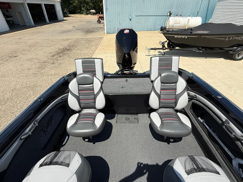 Slide: The Image of 2022 Ranger 1880MS boat interior with dual seats and motor, parked outdoors. - 29