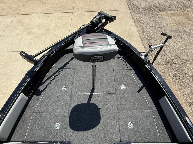 Slide: The Image of 2022 Ranger 1880MS boat deck with seat and trolling motor, parked on pavement. - 8