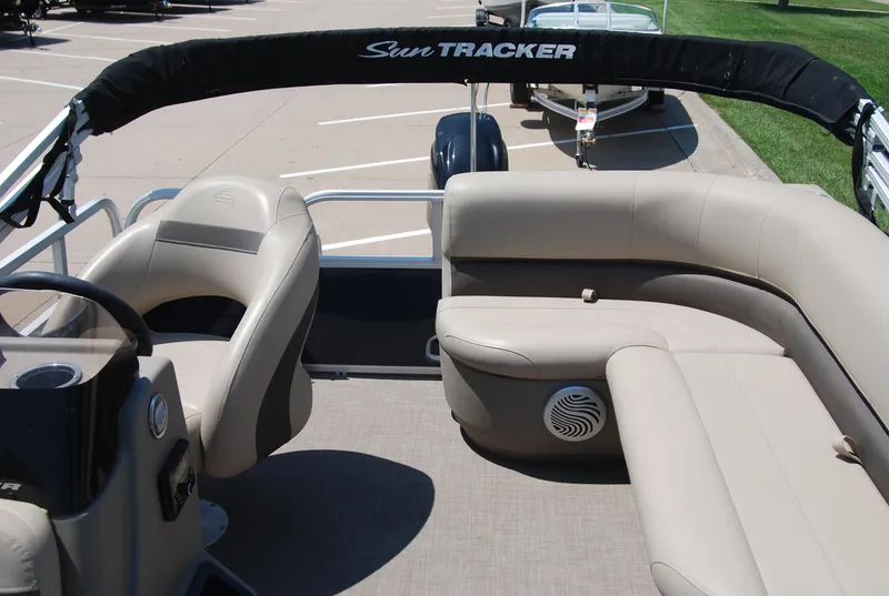 Slide: The Image of 2022 Sun Tracker Bass Buggy 16 XL interior with beige seating and steering console. - 6