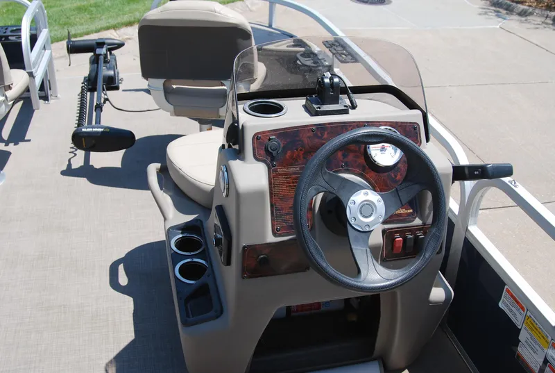 Slide: The Image of 2022 Sun Tracker Bass Buggy 16 XL steering console with cup holders and control panel. - 7