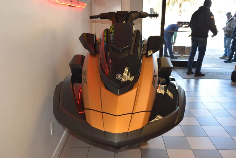 Slide: The Image of 2025 Yamaha WaveRunner FX Cruiser HO in showroom, sleek design, gold and black color scheme. - 8