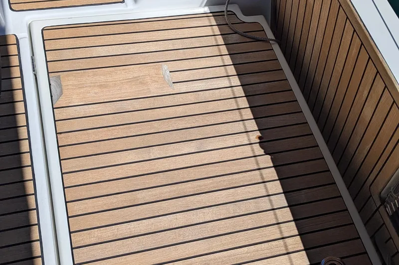 Slide: The Image of Teak deck of 2021 Jeanneau Sun Odyssey 440 sailboat, featuring sleek wood paneling. - 14