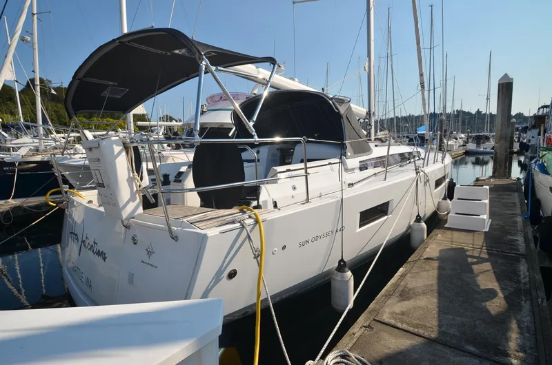 Slide: The Image of 2021 Jeanneau Sun Odyssey 440 yacht docked at marina, featuring sleek design and modern amenities. - 2