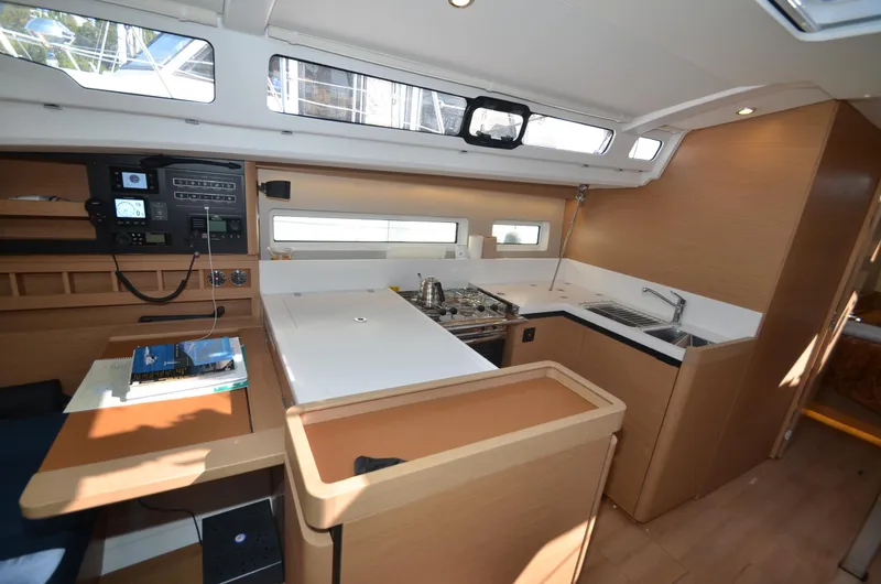 Slide: The Image of Interior of 2021 Jeanneau Sun Odyssey 440 yacht, featuring modern kitchen and navigation area. - 26