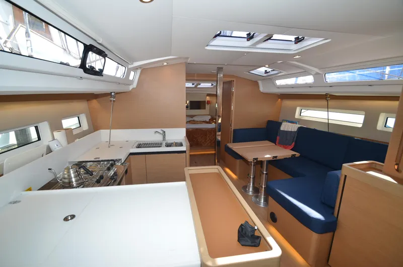Slide: The Image of Interior of 2021 Jeanneau Sun Odyssey 440 yacht, featuring modern kitchen and seating area. - 27