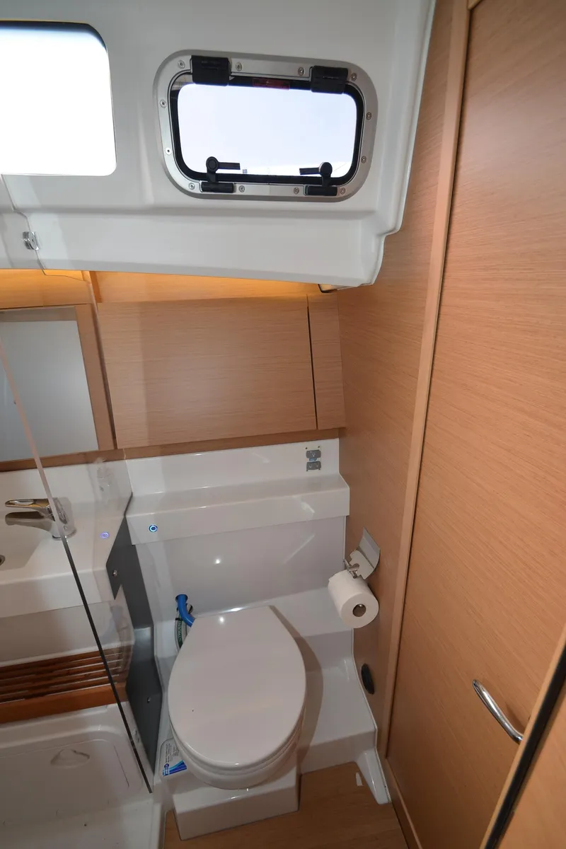 Slide: The Image of 2021 Jeanneau Sun Odyssey 440 bathroom with modern fixtures and wooden cabinetry. - 37