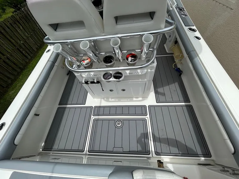 Slide: The Image of 2019 Regulator 23 boat interior with rod holders and cushioned seating. - 10