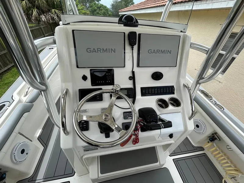 Slide: The Image of 2019 Regulator 23 boat helm with dual Garmin displays and steering wheel. - 14