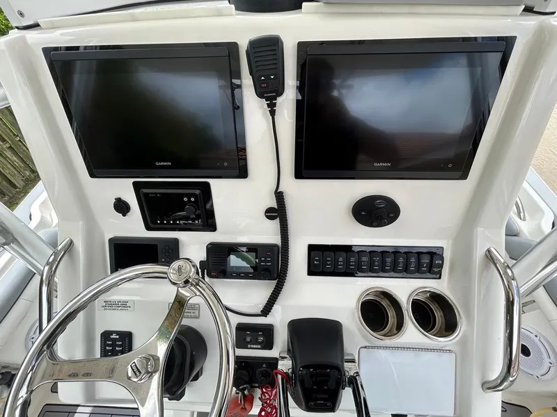 Slide: The Image of 2019 Regulator 23 boat dashboard with dual Garmin displays and control panel. - 23