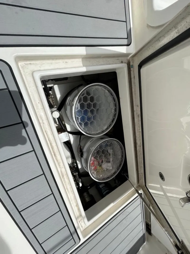 Slide: The Image of 2019 Regulator 23 boat storage compartment with two circular containers. - 25