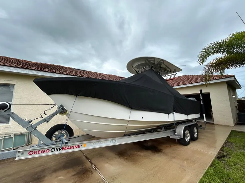 Slide: The Image of 2019 Regulator 23 boat on trailer, covered, parked in driveway near house. - 3