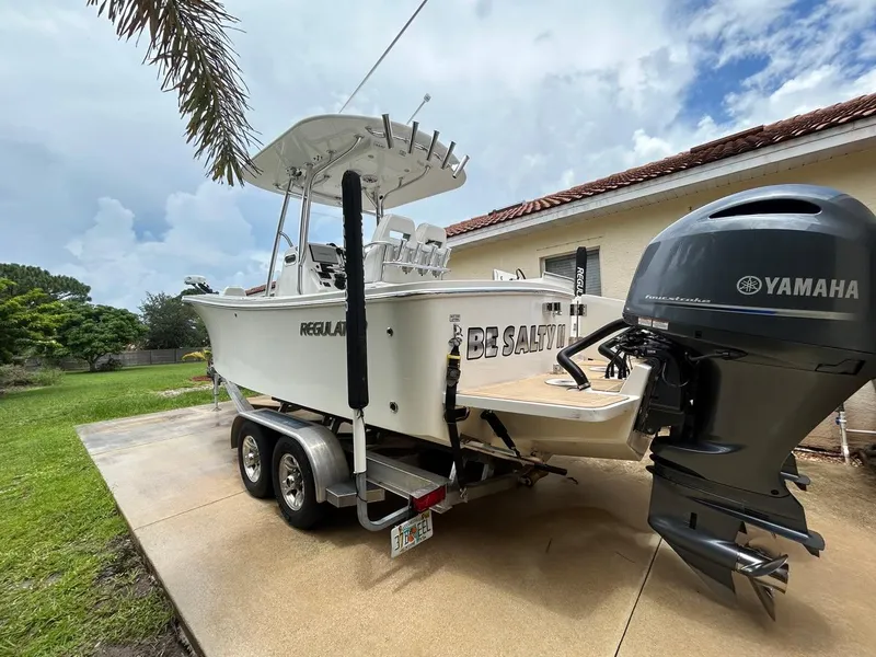 Slide: The Image of 2019 Regulator 23 boat with Yamaha engine on trailer, parked outdoors. - 30