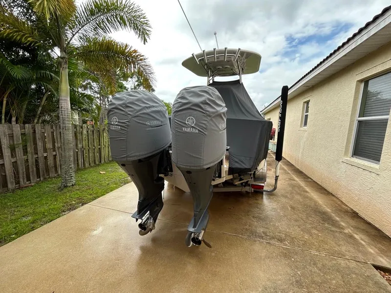 Slide: The Image of 2019 Regulator 23 boat with Yamaha engines, covered and parked on a driveway. - 6