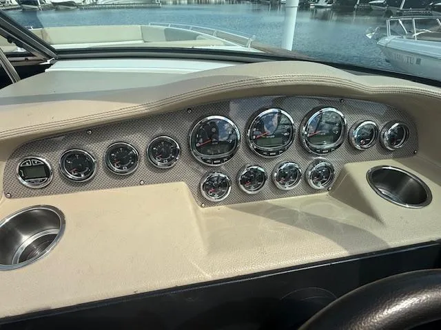 Slide: The Image of Dashboard of a 2013 Regal 3200 Bowrider boat with multiple gauges and cup holders. - 13