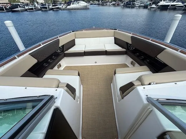 Slide: The Image of 2013 Regal 3200 Bowrider boat interior with spacious seating and waterfront view. - 14
