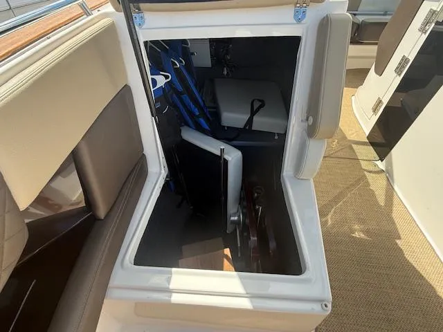 Slide: The Image of 2013 Regal 3200 Bowrider storage compartment with life jackets and equipment. - 15