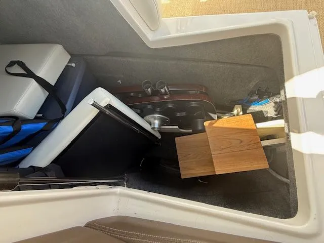 Slide: The Image of Storage compartment in a 2013 Regal 3200 Bowrider boat, containing various equipment and accessories. - 16