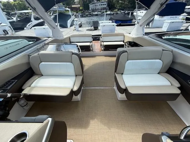 Slide: The Image of 2013 Regal 3200 Bowrider interior with beige seating and spacious layout at a marina. - 20