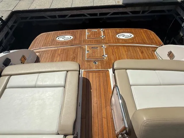 Slide: The Image of 2013 Regal 3200 Bowrider boat with teak deck and cushioned seating. - 23