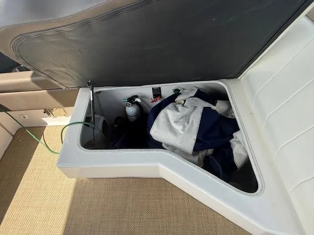 Slide: The Image of Open storage compartment in 2013 Regal 3200 Bowrider boat with items inside. - 25