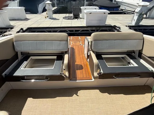 Slide: The Image of 2013 Regal 3200 Bowrider interior with open storage compartments and wooden flooring. - 26