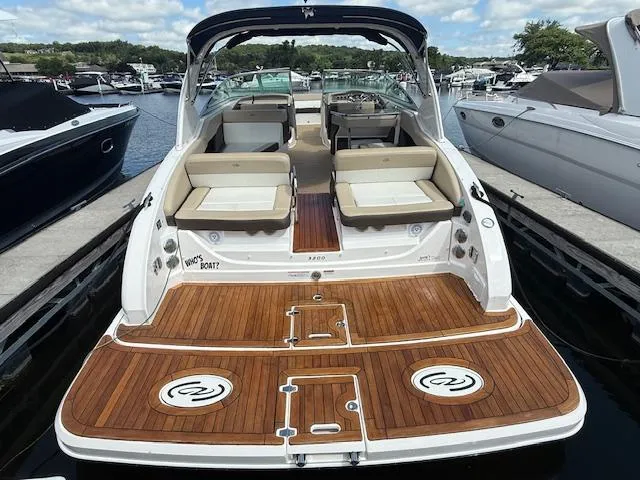 Slide: The Image of 2013 Regal 3200 Bowrider with spacious deck and seating, docked at a marina. - 3