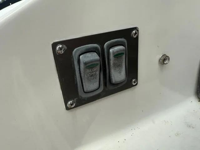 Slide: The Image of Control panel with switches for bilge and lights on a 2013 Regal 3200 Bowrider boat. - 32
