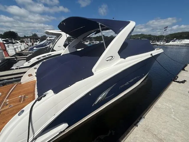 Slide: The Image of 2013 Regal 3200 Bowrider boat docked at marina under clear blue sky. - 36