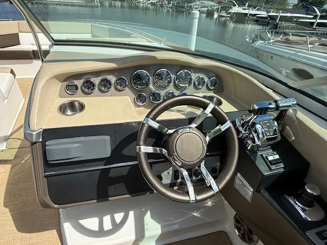 Slide: The Image of 2013 Regal 3200 Bowrider dashboard with steering wheel and controls, docked at marina. - 8