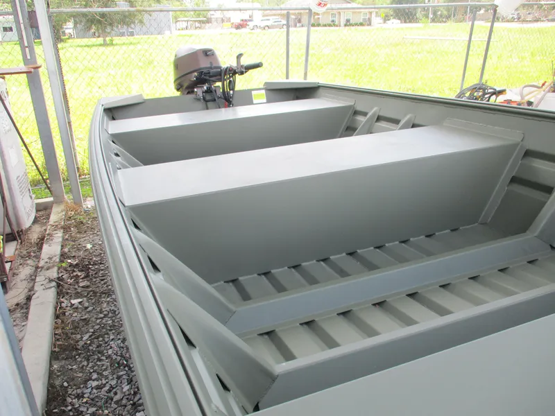 Slide: The Image of 2025 Alweld 1448 DS boat with motor, parked in a fenced area. - 6