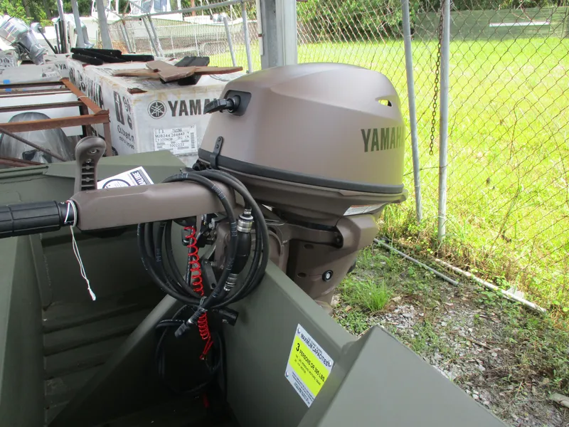 Slide: The Image of 2025 Alweld 1448 DS boat with Yamaha outboard motor, parked near a chain-link fence. - 8