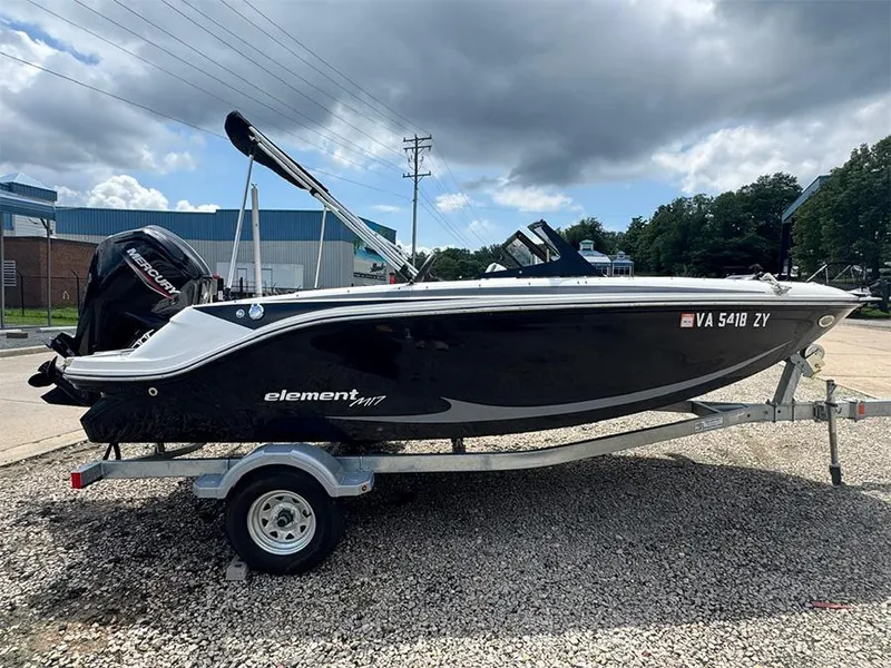 Slide: The Image of 2023 Bayliner Element M17 boat on trailer, parked outdoors under cloudy sky. - 5
