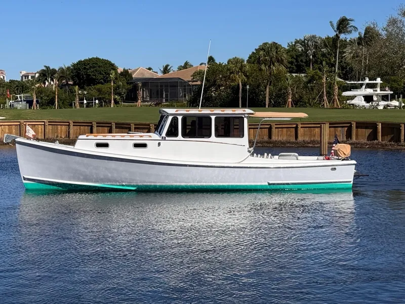 Slide: The Image of 1987 West Bay James Beal 31 Hardtop Lobster Boat on calm water, clear sky background. - 0