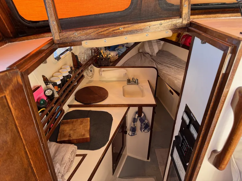 Slide: The Image of Interior of 1987 West Bay James Beal 31 Hardtop Lobster Boat, featuring cozy cabin and kitchenette. - 2