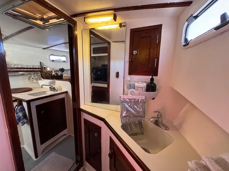 Slide: The Image of Interior of 1987 West Bay James Beal 31 Lobster Boat, featuring compact kitchen and bathroom. - 3
