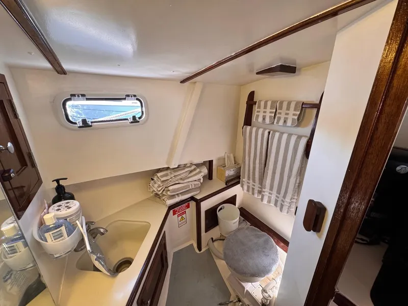 Slide: The Image of 1987 West Bay James Beal 31 Hardtop Lobster Boat bathroom with sink, towels, and window. - 5