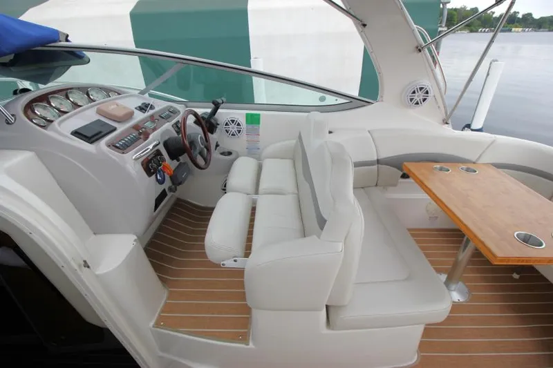 Slide: The Image of 2006 Chaparral Signature 290 boat interior with helm, seating, and wooden table. - 11