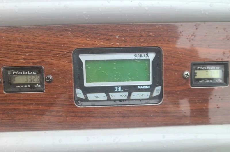 Slide: The Image of Control panel of a 2006 Chaparral Signature 290 boat with Hobbs meters and JBL marine radio. - 13