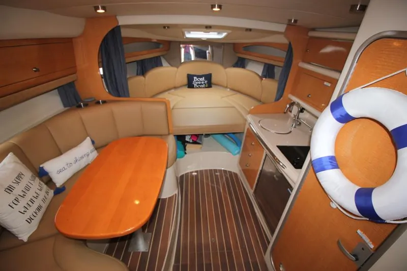 Slide: The Image of 2006 Chaparral Signature 290 cabin interior with seating, kitchenette, and nautical decor. - 14
