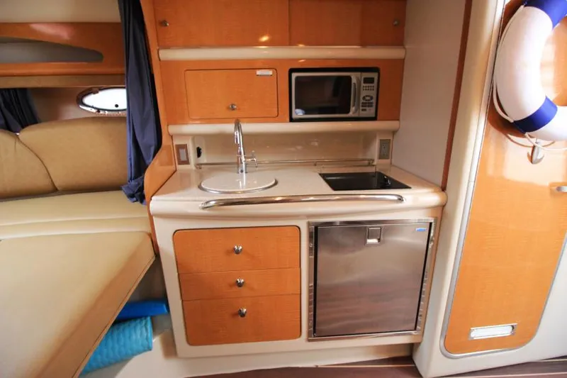 Slide: The Image of 2006 Chaparral Signature 290 interior kitchen with sink, microwave, and compact fridge. - 19