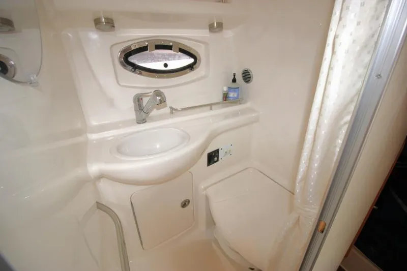 Slide: The Image of 2006 Chaparral Signature 290 bathroom with sink, porthole, and shower curtain. - 20