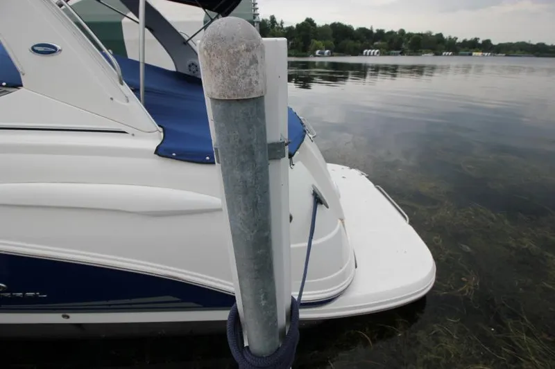 Slide: The Image of 2006 Chaparral Signature 290 boat docked by a lake with a mooring post. - 3