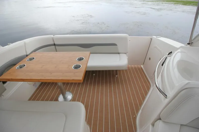 Slide: The Image of 2006 Chaparral Signature 290 boat interior with seating and wooden table on deck. - 7