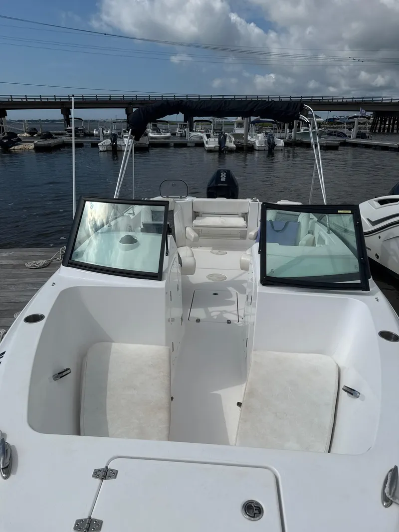 Slide: The Image of 2024 Aquasport 2200 Dual Console boat docked at marina under cloudy sky. - 2