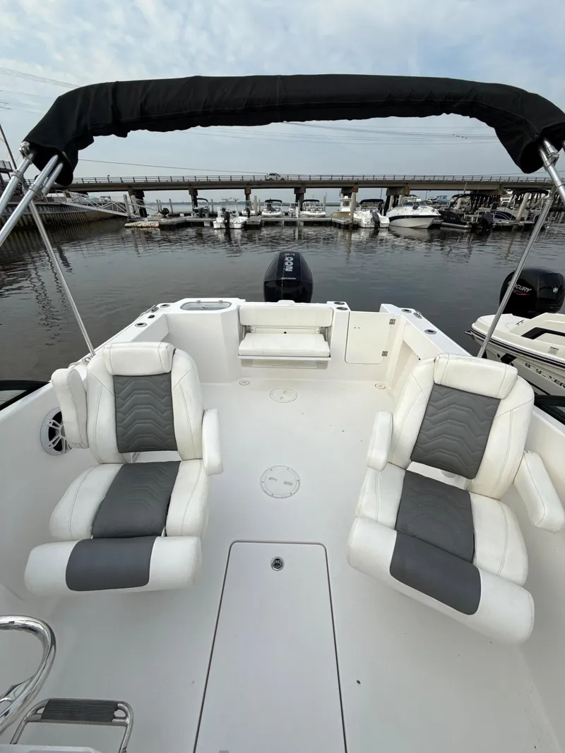 Slide: The Image of 2024 Aquasport 2200 Dual Console boat interior with seating, docked at marina. - 5