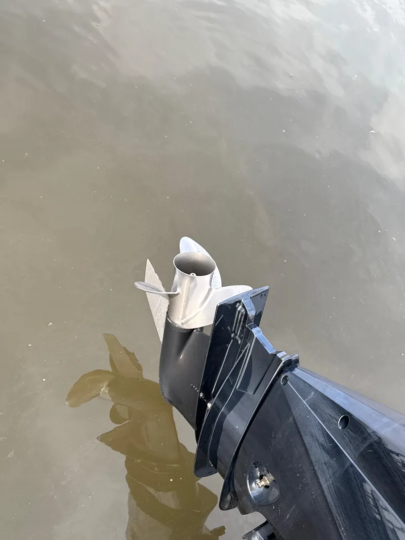 Slide: The Image of Outboard motor of 2024 Aquasport 2200 Dual Console on calm water. - 8