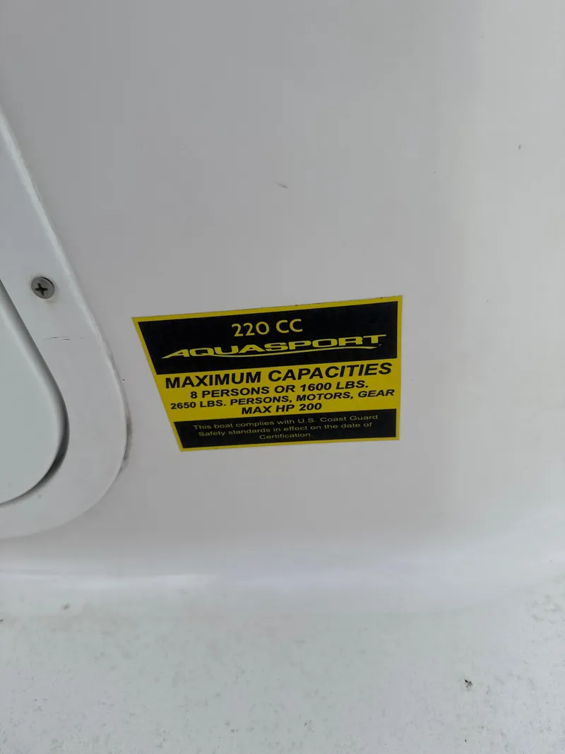 Slide: The Image of 2024 Aquasport 2200 Dual Console capacity label detailing weight and passenger limits. - 9