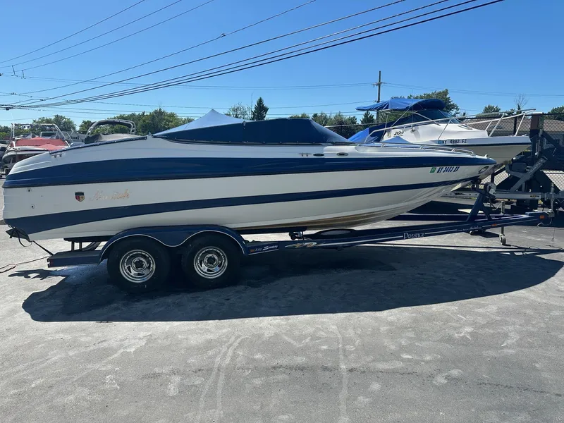 Slide: The Image of 1998 Mariah Z222 Shabah boat on trailer, parked outdoors under clear blue sky. - 1